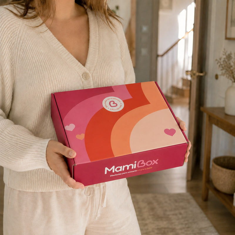 Mujer embarazada sostiene en casa su caja de suscripción MamiBox recién recibida